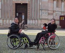 Jessica e Matteo in carrozzina pronti per visitare il Battistero di Parma. Sono gli autori di Parmaccessibile, la guida turistica esperienziale per le disabilità motorie in cui sono presenti anche i Musei del Cibo (Courtesy Jessica e Matteo)